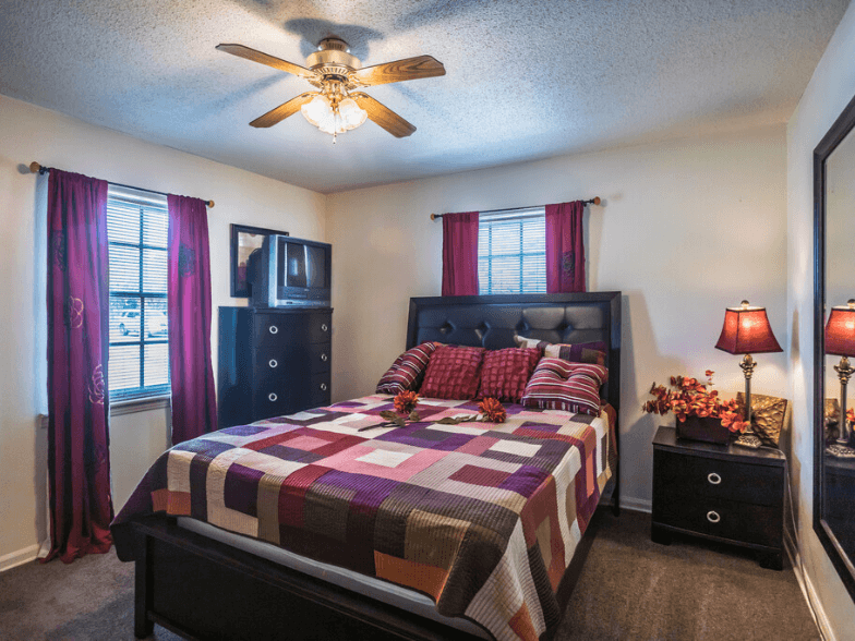 a bedroom with a bed and a ceiling fan