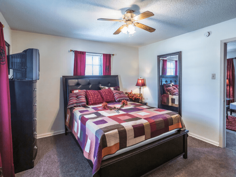 a bedroom with a bed and a ceiling fan