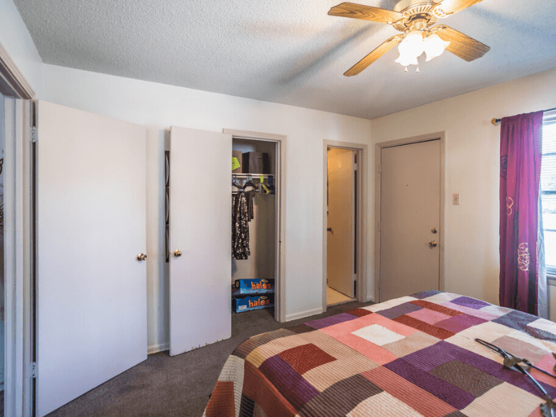 a bedroom with a bed and a ceiling fan