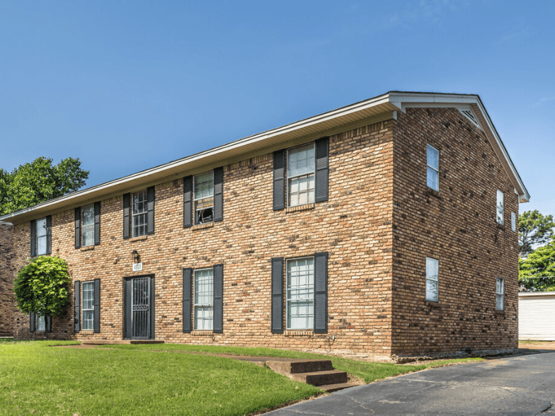 the front of a brick building with windows and a roof