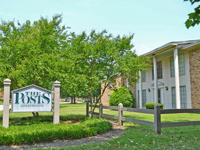 a sign for the ross apartments in front of a fence