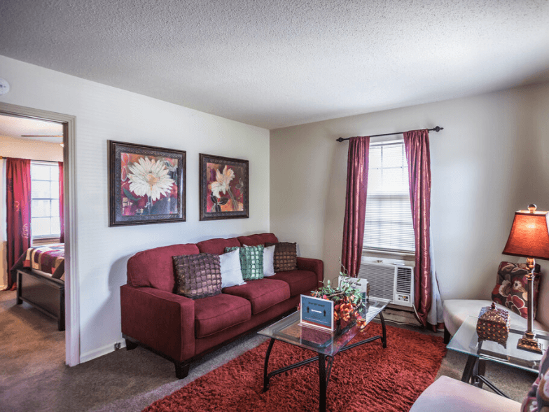 a living room with a red couch and a glass table