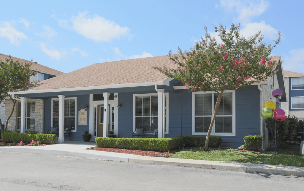 a blue house with balloons in the front yard