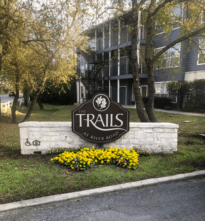 a sign for the trails in front of a building