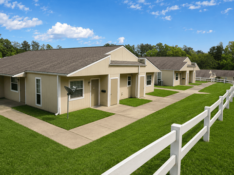 A white picket fence separates a row of houses.