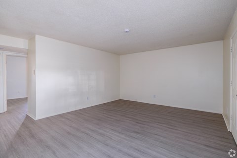 Empty room with light grey flooring and white walls.