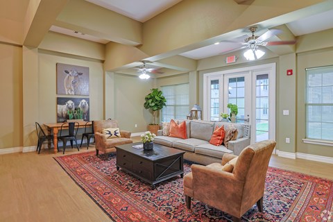 A living room with a rug, a couch, a coffee table, and a dining table.