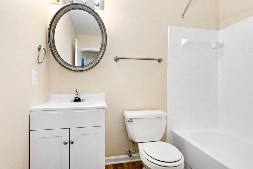 A white toilet sits next to a white sink in a small bathroom.
