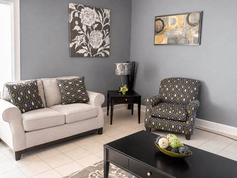 A living room with a couch, chair, and table.