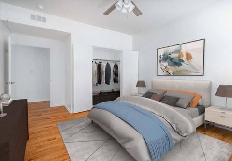 A bedroom with a bed, nightstand, and a painting on the wall.
