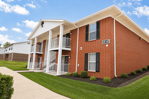 A red brick building with a white porch and a sign that says "1074".