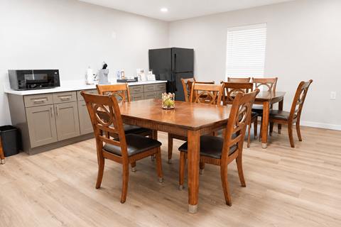 A kitchen with a table and chairs in the middle of the room.