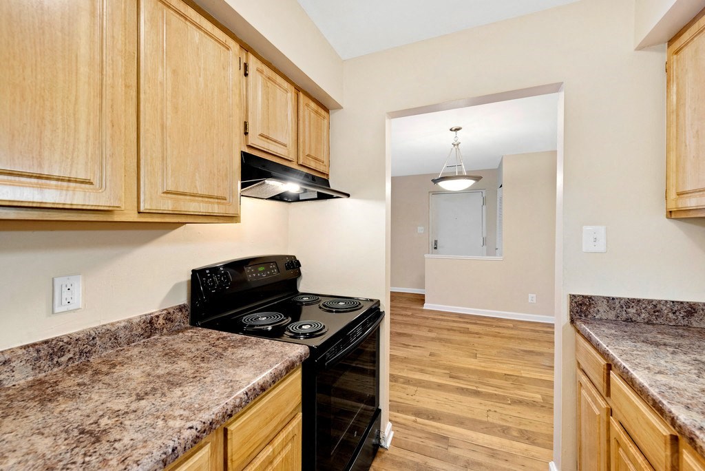A kitchen with wooden cabinets and granite countertops.