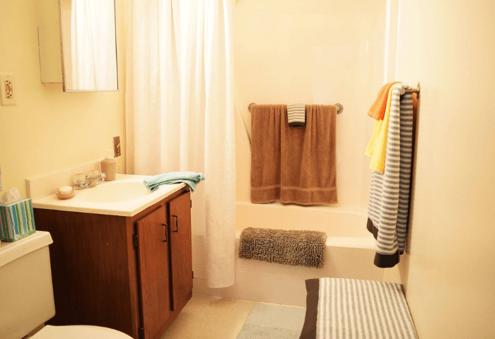 A bathroom with a toilet, sink, and towel rack.