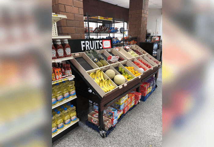 A fruit stand in a store with a sign that says "Fruits".