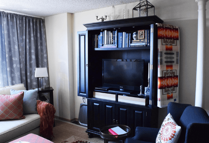 A living room with a black entertainment center and a white couch.