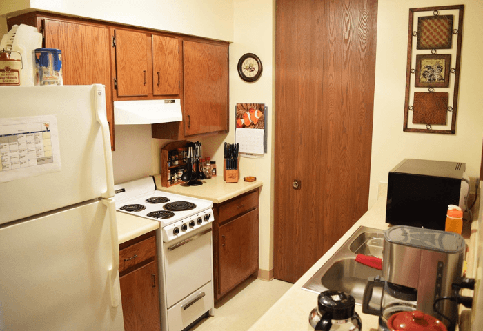 A kitchen with a white fridge, white stove, and a white oven.