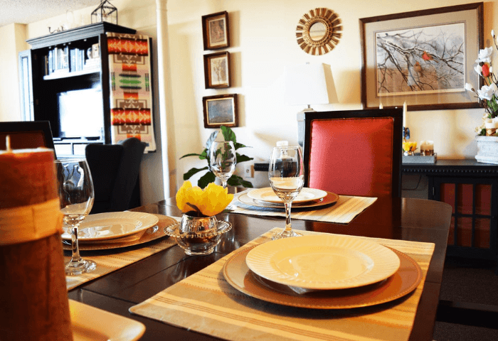 A dining table set with plates and glasses.