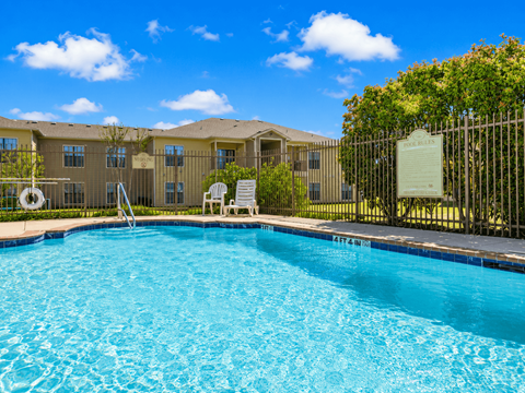 A pool in front of a building with a sign on a fence.