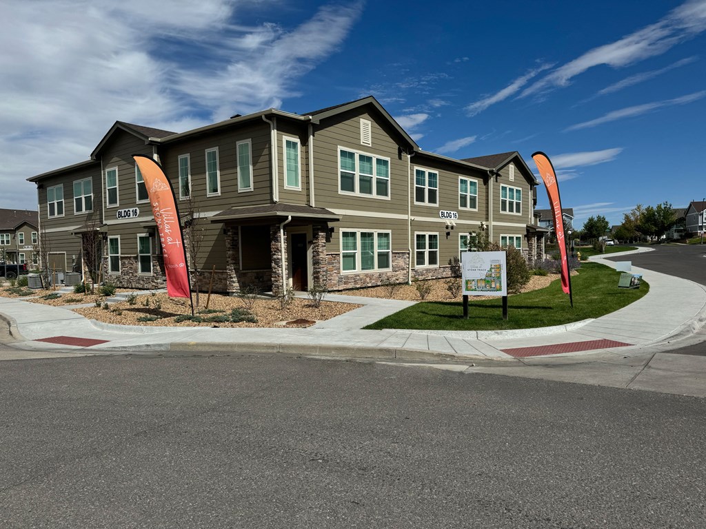 an apartment building with orange banners in front of it