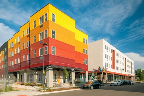 A multi-story building with a yellow, red, and white exterior.
