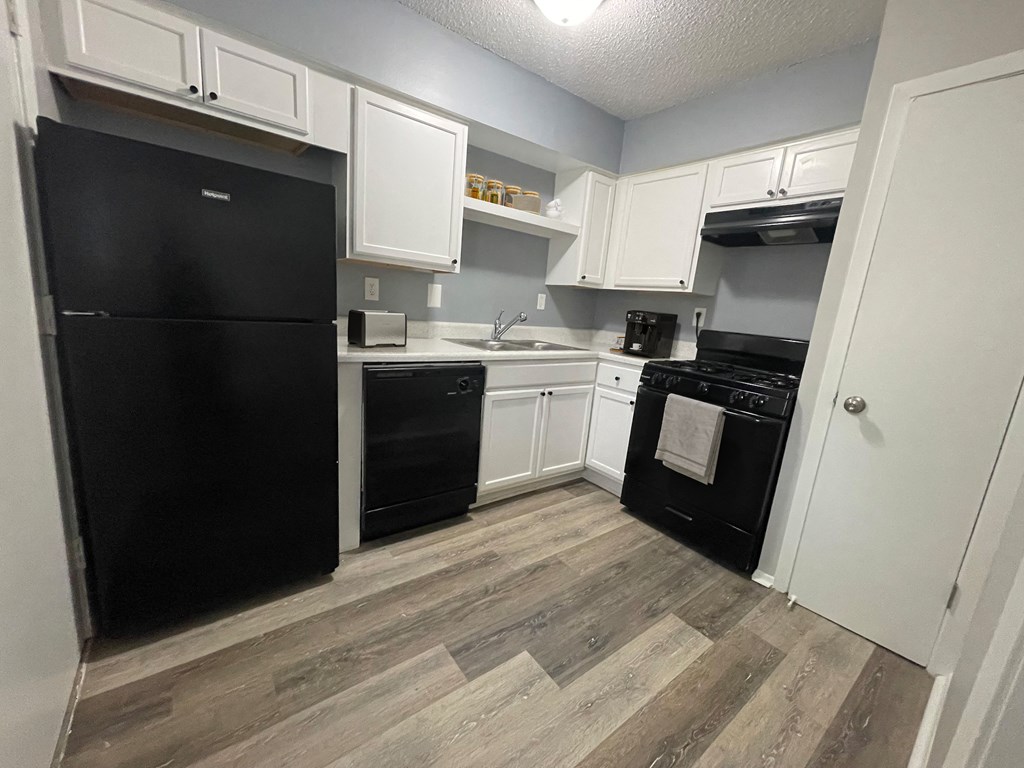 a kitchen with black appliances and white cabinets at The Junction, Memphis, TN