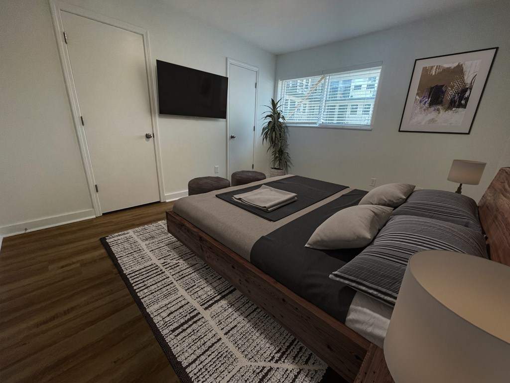 a bedroom with a bed and a tv on the wall at The Courts Midtown, Memphis, TN, 38104