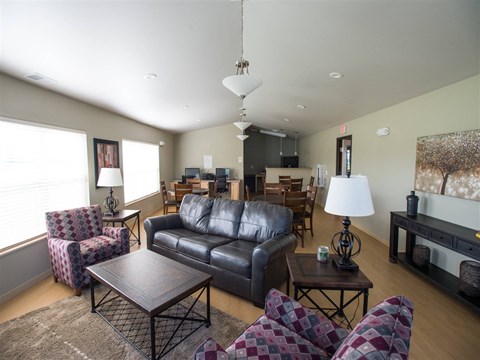 A living room with a black leather couch and a wooden coffee table.