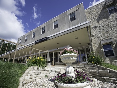 A stone building with a white awning and a fountain in front.