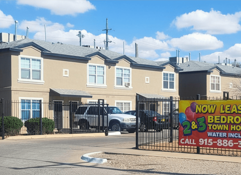 A sign in front of a building advertises that 2 and 3 bedroom townhouses are now lease.