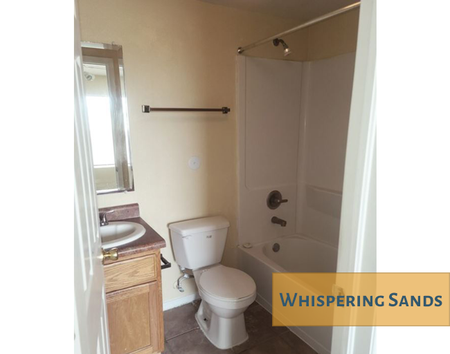 A bathroom with a toilet, sink, and shower.