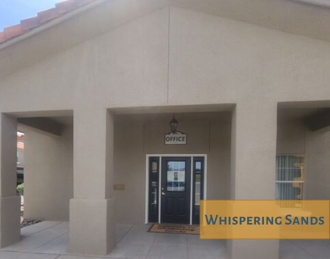 The front of a building with a sign that says Whispering Sands.