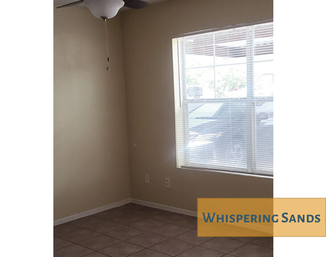 A room with a window and a fan.