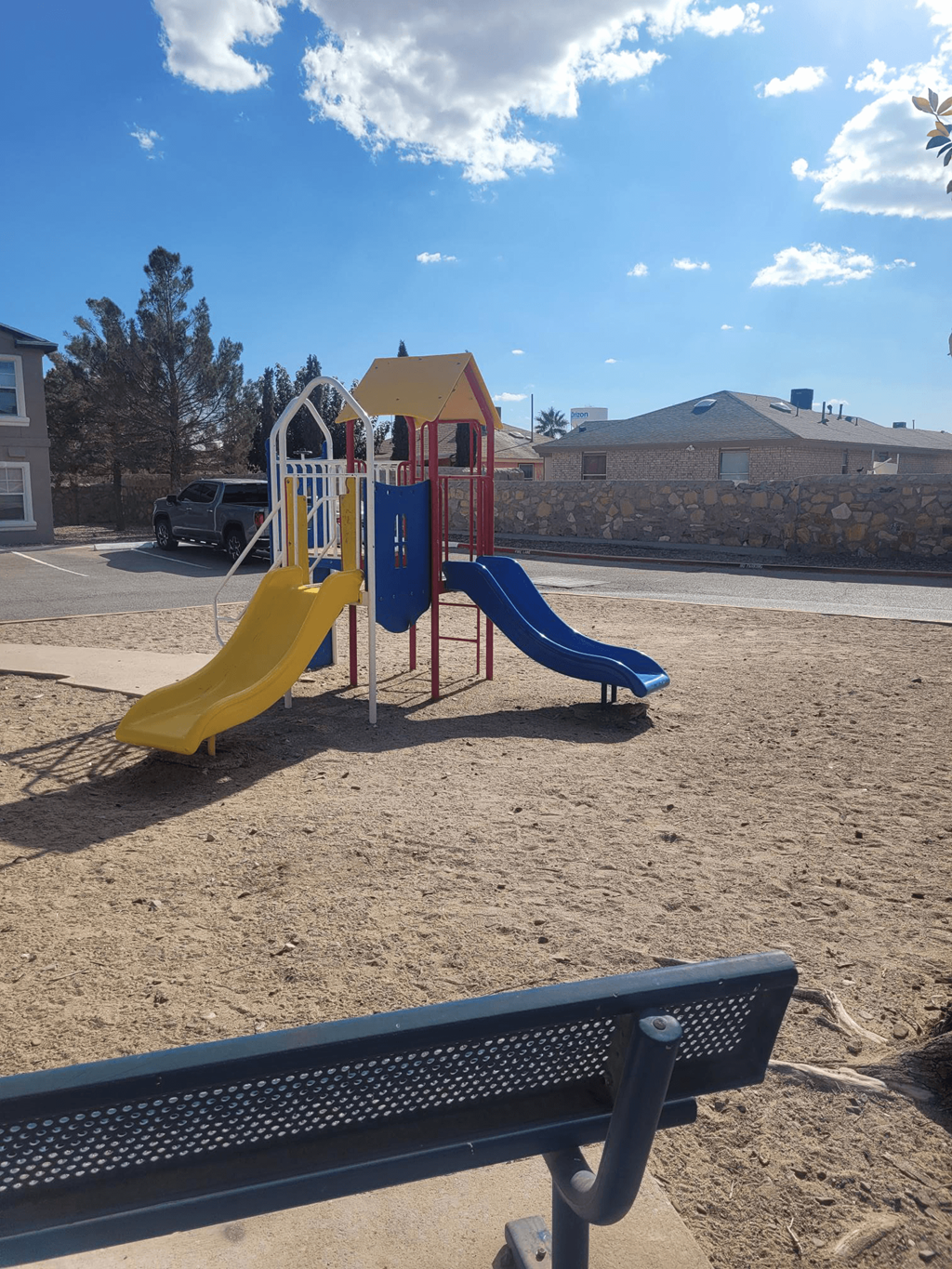 a playground with two slides and a bench
