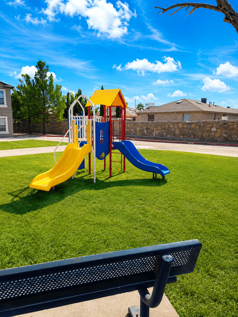 A playground with a yellow and blue slide.