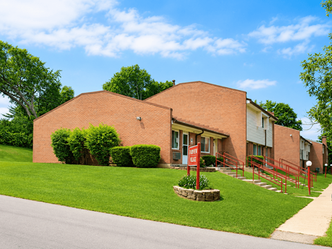 A red brick building with a red gate in front.