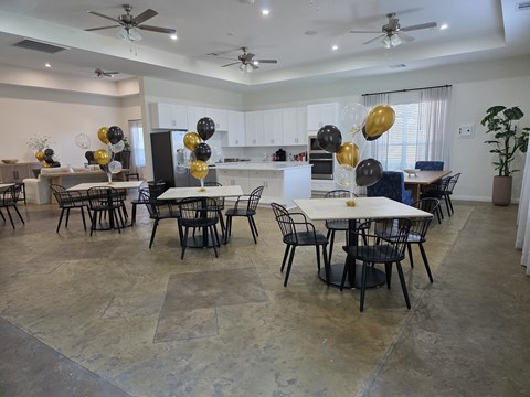 A dining room with a table surrounded by chairs and balloons.