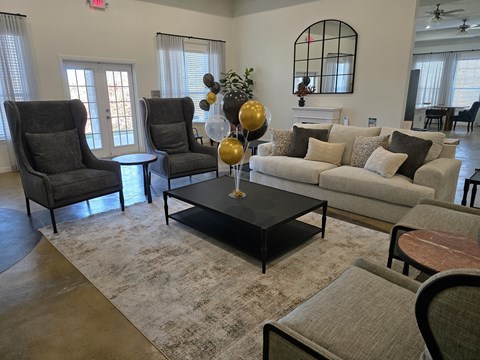 A living room with a grey couch, a black coffee table, and a fireplace.