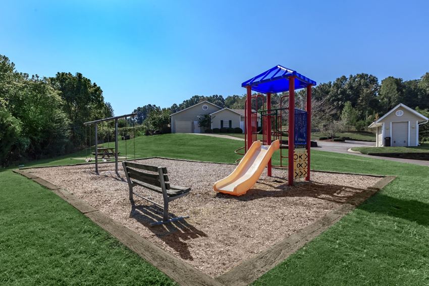 our park has a playground with a slide and a bench