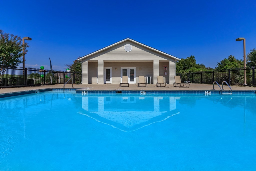 a swimming pool with a house in the background