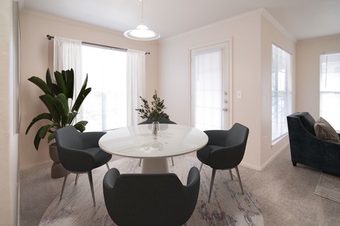 A modern dining room with a round table and chairs.