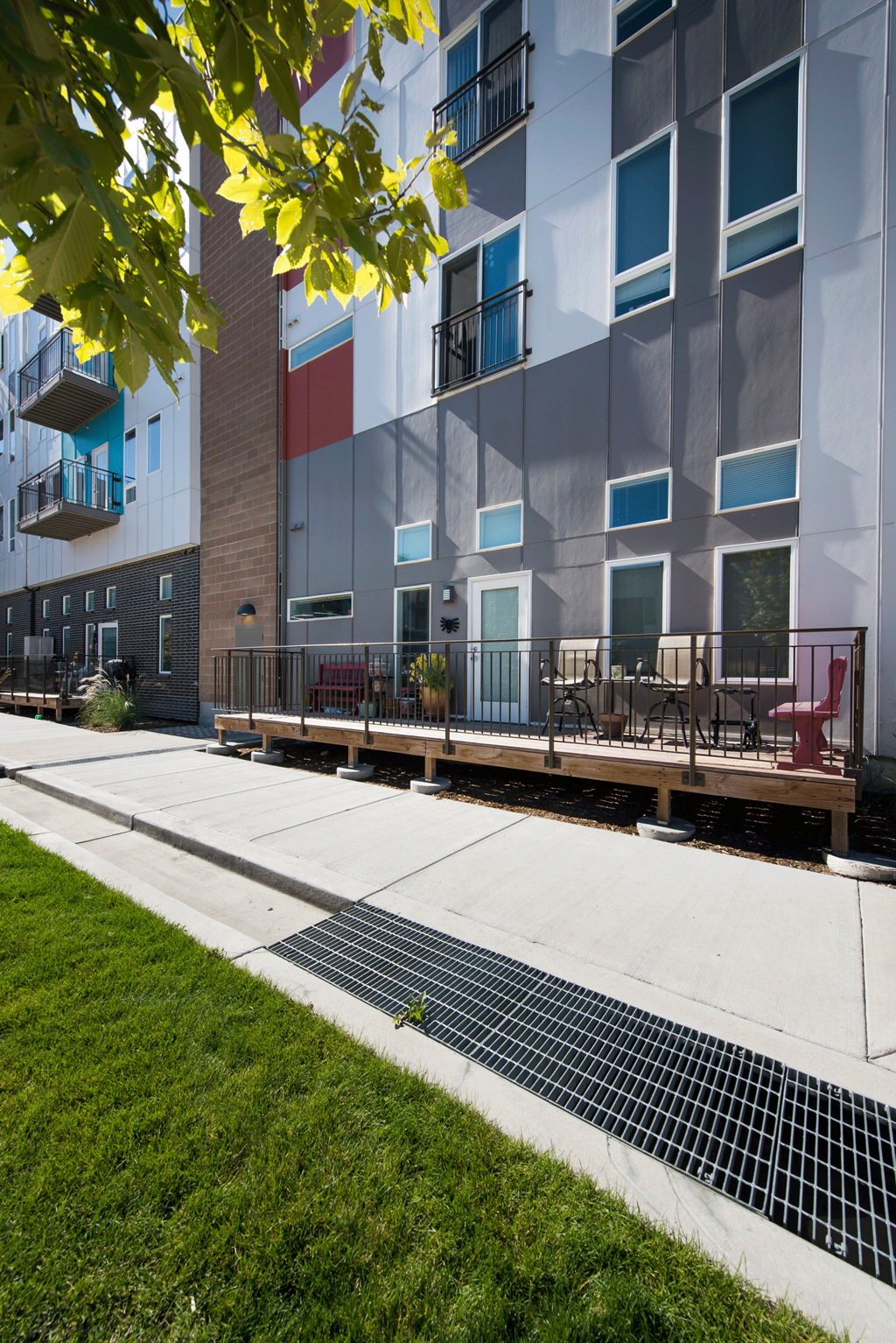 an exterior view of an apartment building with a sidewalk and patio