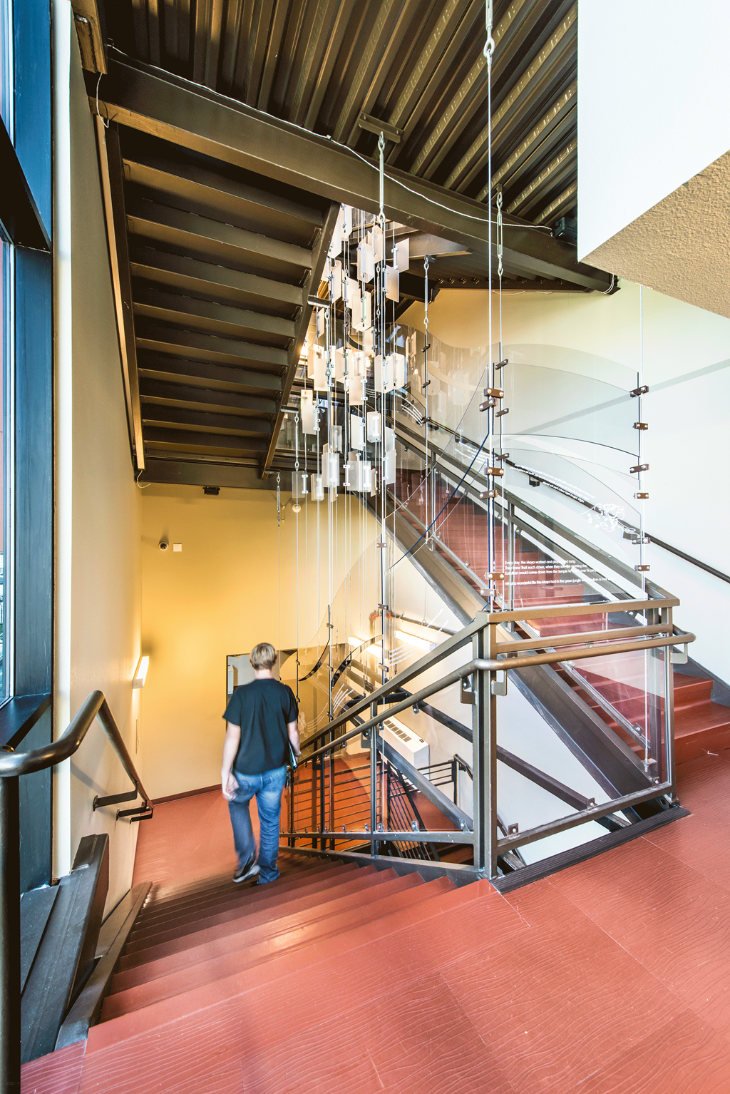 a man walking down a staircase with a glass railing
