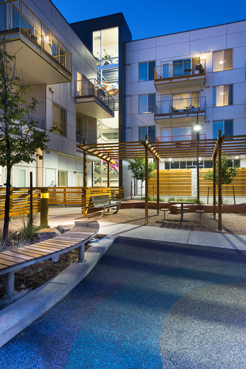 an apartment building with a pool and benches