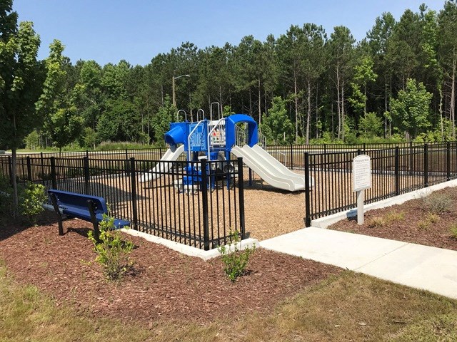 a playground with a blue slide and a bench