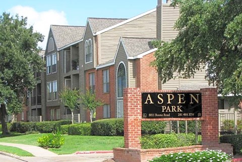 an aspen park sign in front of an apartment building