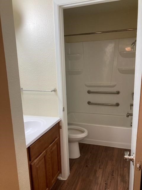 A white toilet sits in a bathroom next to a white sink.