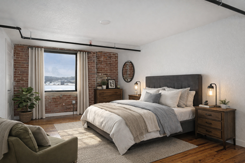 A bedroom with a large bed, a chair, and a window with a view.