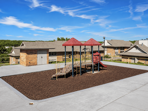 A playground with a red roofed structure and a slide.