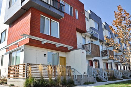 a red and white house with a sidewalk in front of it